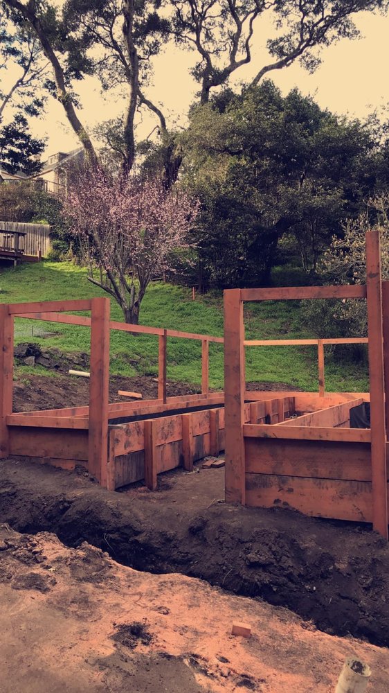 Two redwood raised garden beds under construction in a residential backyard
