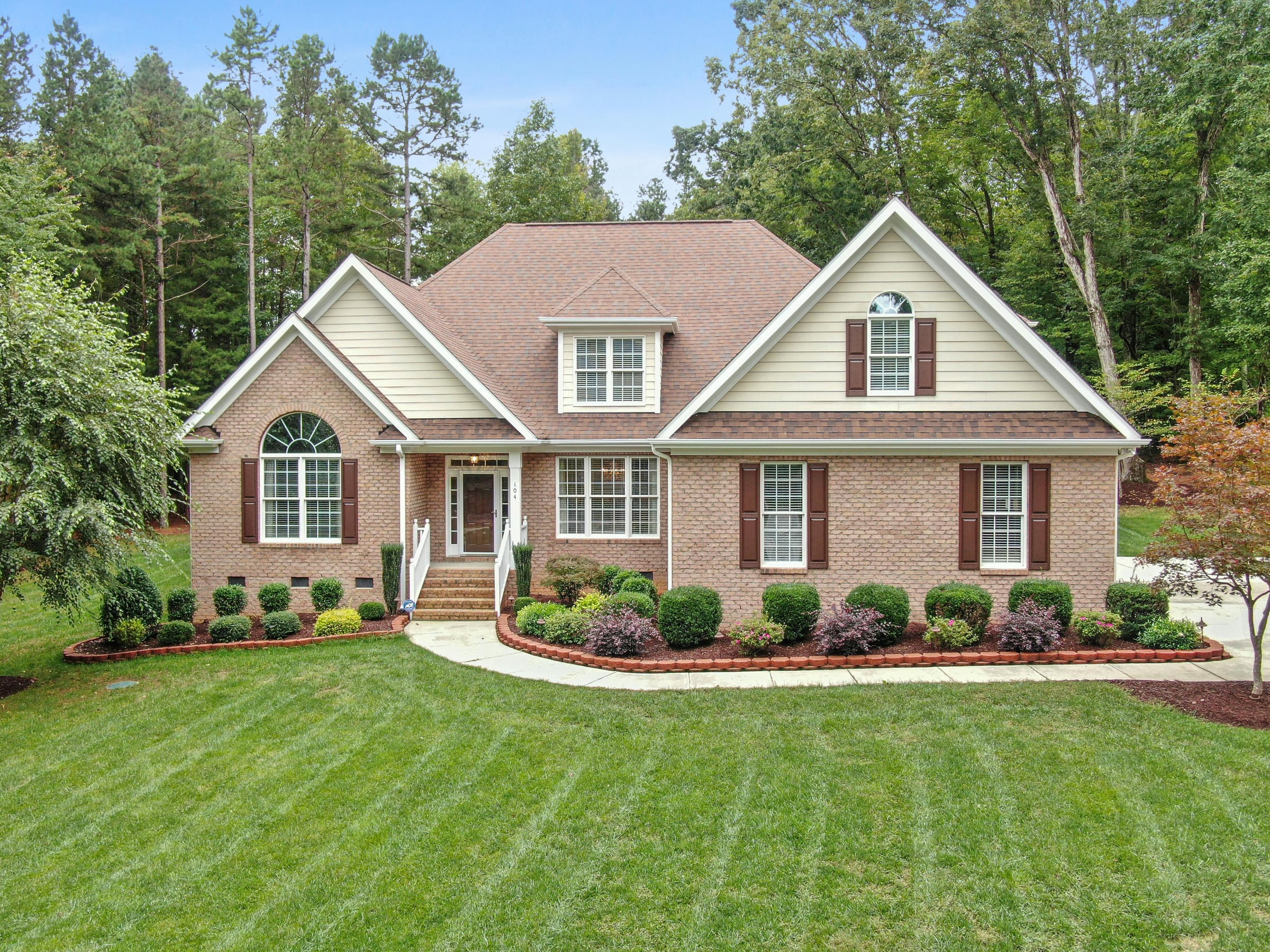 Residential home with a professionally striped mowing pattern on the front lawn